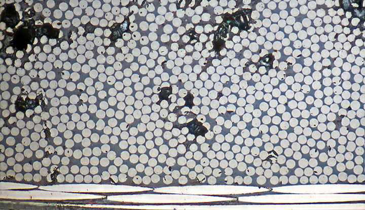 Sections through carbon fibres (7µm diameter) in laminate (metallurgical microscope, vertical reflected light)